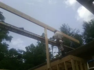 Carpenter setting a ridge beam over a new addition frame — Ice Dam Removal by Roofing Brothers in Julian
